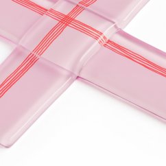 Szklany krzyż chrzcielny w pastelowym różu z delikatnymi liniami.